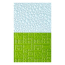Two textured paper sheets, one light blue with bubble pattern and one green with geometric pattern, on a white background.