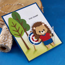 Card with a hedgehog character holding an arrow, target, and trees on a blue background
