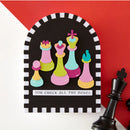 Colorful chess pieces on a blackboard with text against a red background