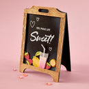 Chalkboard sign with decorative elements and 'You make life sweet!' text on a pink background