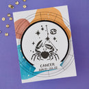 Card with Cancer zodiac sign design on a purple background