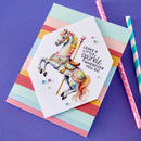 Card with carousel horse illustration and text on a colorful striped background