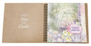 Open spiral-bound notebook with motivational text and floral design on a white background