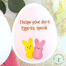 Easter egg-shaped card with bunnies and text on a floral background