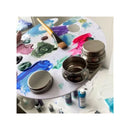 Artistic setup with a paint palette, brushes, and containers on a white background