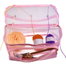 Pink knitting bag with yarn and tools on a white background