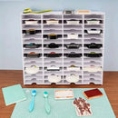 White storage cabinet with multiple drawers on a wooden surface with craft items.