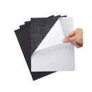 Hand holding a stack of black and white felt sheets on a white background