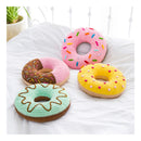 Four colorful crocheted donut toys on a white surface.