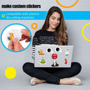 Woman using a laptop with custom stickers, including a hand holding a sticker.