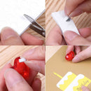 Step-by-step process of using a heart-shaped cutter to cut out a red heart from paper.