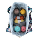 Backpack with colorful yarn balls inside on a white background