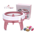 Pink knitting machine with accessories and yarn on a white background