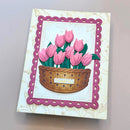 Greeting card with pink tulips in a basket on a light background
