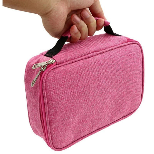 Pink toiletry bag with a hand holding it on a white background