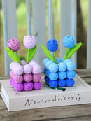 Crocheted tulips in pink and blue on a book with blurred background