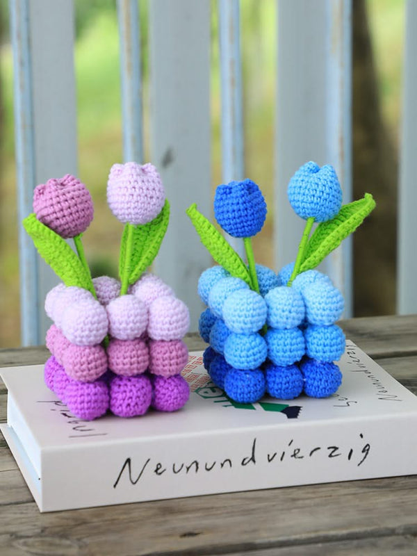 Crocheted tulips in pink and blue on a book with blurred background
