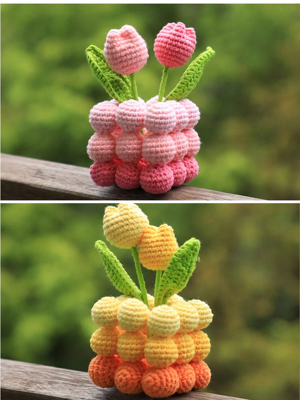 Two sets of crocheted tulip flowers on a wooden surface with a blurred green background.