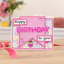 Birthday card with pink and multicolor design on a wooden surface