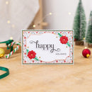 Holiday card with 'happy holidays' text on a wooden surface with Christmas decorations.