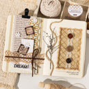Decorative notebook with textured pages, buttons, and twine on a neutral background