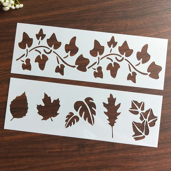 Two sheets of leaf stencils on a wooden surface
