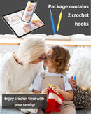 Woman and child crocheting together with crochet hooks and a tablet showing instructions.