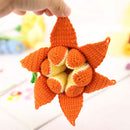Handmade crochet pumpkin toy held by a hand with a blurred background