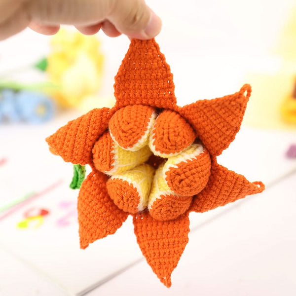 Handmade crochet pumpkin toy held by a hand with a blurred background