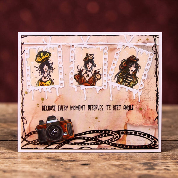 Decorative card with illustrations of a woman, a camera, and text on a wooden surface.