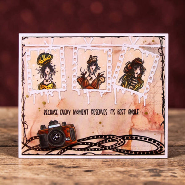 Decorative card with illustrations of a woman, a camera, and text on a wooden surface.