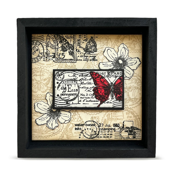 Decorative wall art with butterfly and floral design in a black frame.