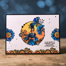 Decorative card with floral and fantasy design on a wooden surface with a blurred blue background