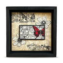 Decorative wall art with butterfly and floral design in a black frame.