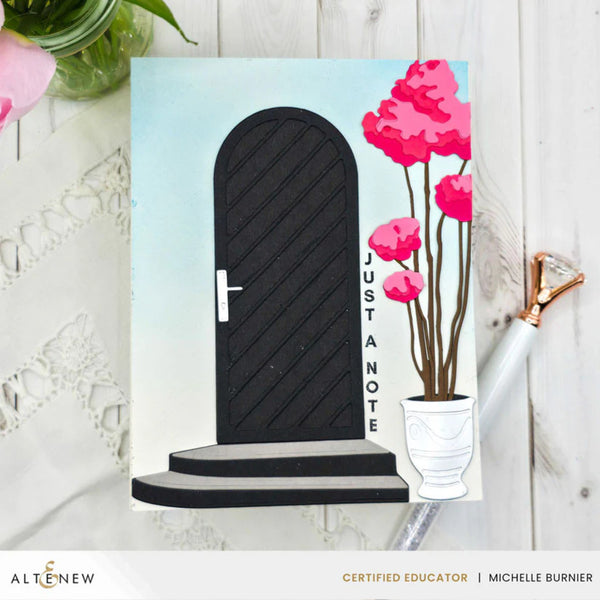 Greeting card with a black door and pink flowers on a white background, featuring the brand 'Altenew'.