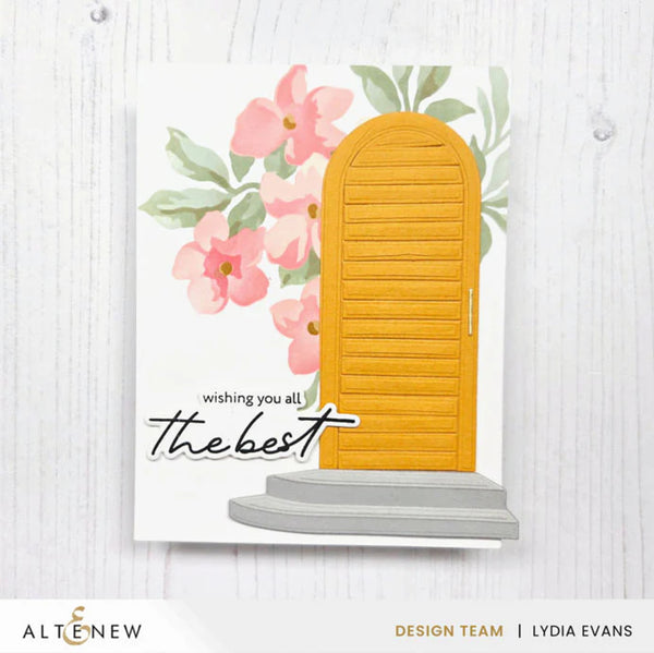 Card with a yellow door, pink flowers, and text 'wishing you all the best' on a white background.