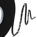 Black floral-patterned ribbon with a spool on a white background