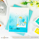 Card with ocean-themed design and 'sending oceans of love' text, surrounded by crafting tools and flowers on a white background.