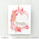 Card with pink and orange leaf design and 'hugs' text on a white background