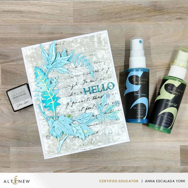 Card with blue leaf design and two spray bottles on a wooden surface, featuring the Alté New brand.