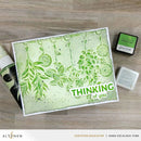 Card with green floral design and 'Thinking of you' text on a wooden surface, featuring Altenew products.