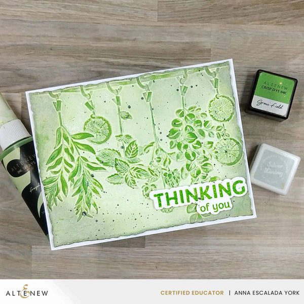 Card with green floral design and 'Thinking of you' text on a wooden surface, featuring Altenew products.
