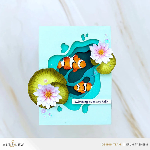 Card with clownfish and water lilies on a light blue background, featuring the brand 'Altenew'.