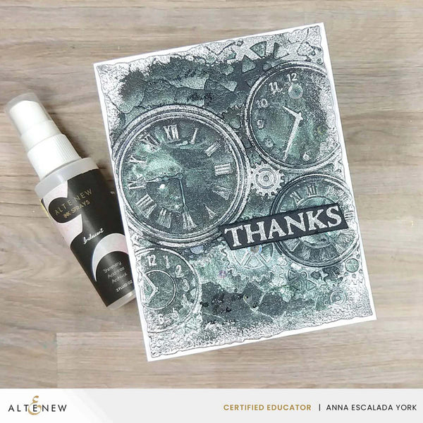 Card with clock design and 'THANKS' text, next to a spray bottle on a wooden surface.