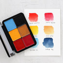Set of watercolor paints with color swatches on a white surface