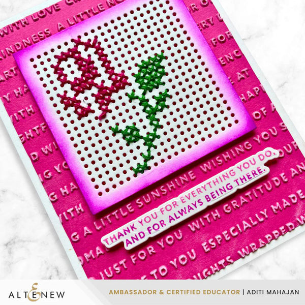 Cross-stitched card with pink border and text, featuring a heart and leaves design.