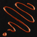 Brown sauce drizzle on a black background