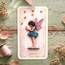 Card with a fairy holding a butterfly on a decorative surface with flowers and candles.
