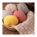 Basket with colorful yarn balls on a wooden surface