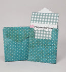 Teal fabric envelope with a gingham card inside on a gray background